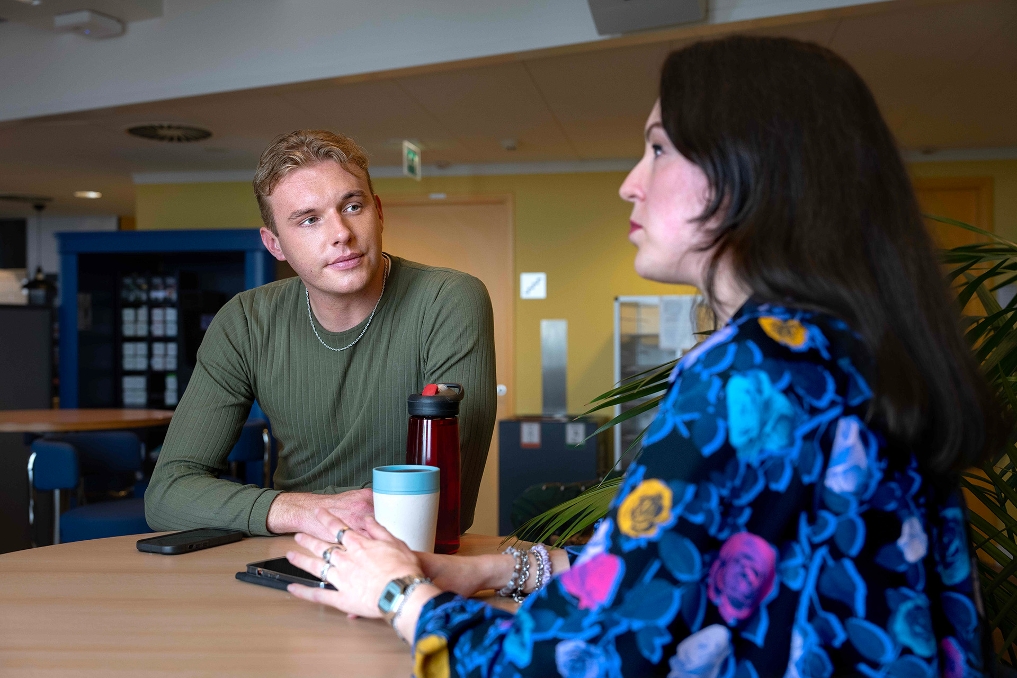 Twee collega's van JenV met elkaar in gesprek aan een staantafel